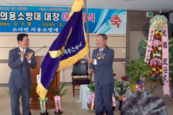 이기붕 이임대장으로부터 김대회 신임대장이 의용소방대기를 전달 받았다.