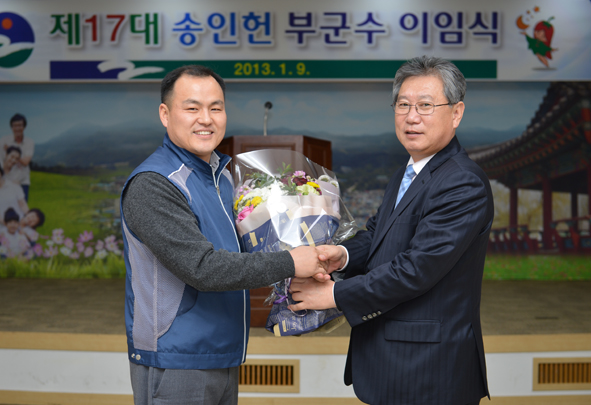 이화영 음성공무원노조 수석지부장이 이임하는 송인헌 부군수에게 꽃다발을 전달하고 있다.