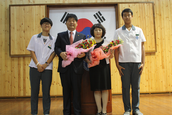 학생대표로부터 꽃다발을 받고 기념촬영하는 우성수 선생 부부.