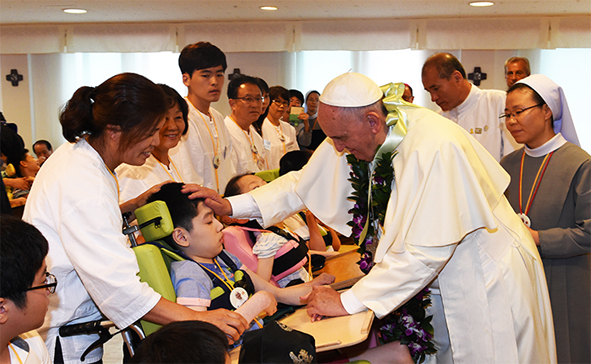 프란치스코 교황이 꽃동네를 방문해 장애인을 축복하고 있다.