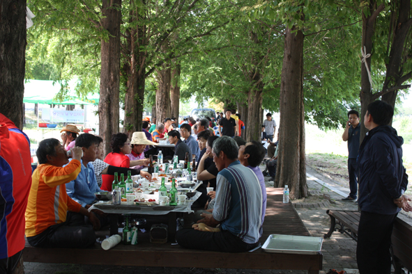 응천공원 가로수 밑에서 식사하고 있는 생극수박작목회원들.