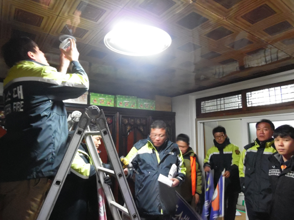 생극의용소방대원들이 관내 가정에서 화재감지기를 설치하고 있다.