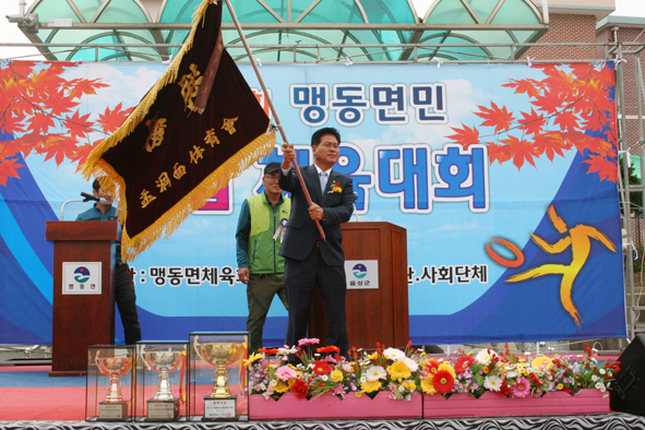 맹동면민체육대회 개회식에서 대회기를 흔들고 있는 김창호 회장.