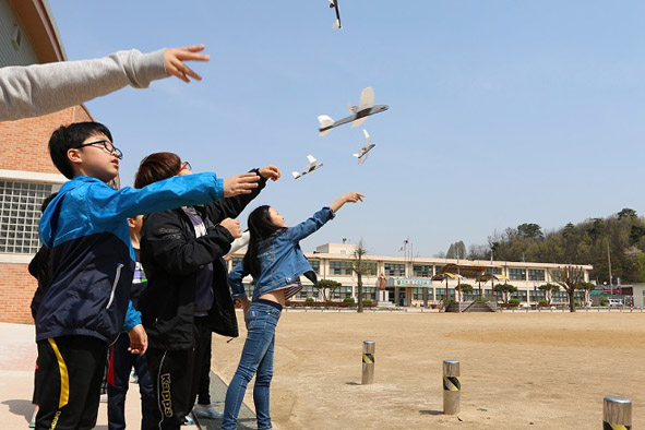 생극초 어린이들이 과학의 날을 맞아 모형비행기를 날리고 있다.
