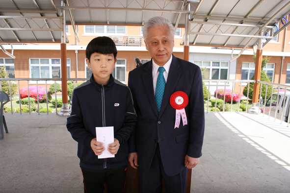 박희남 총동문회장이 한 학생에게 장학금을 전달했다.