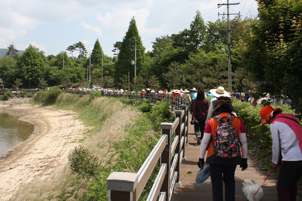 주민들이 양덕저수지 둘레길을 짚신 신고 걷기대회에 참가하고 있다.