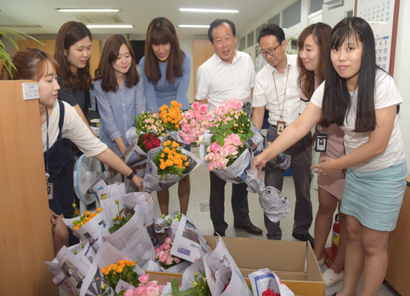 인삼특작부 직원들이 구입한 꽃을 들고 촬영에 임하고 있다.