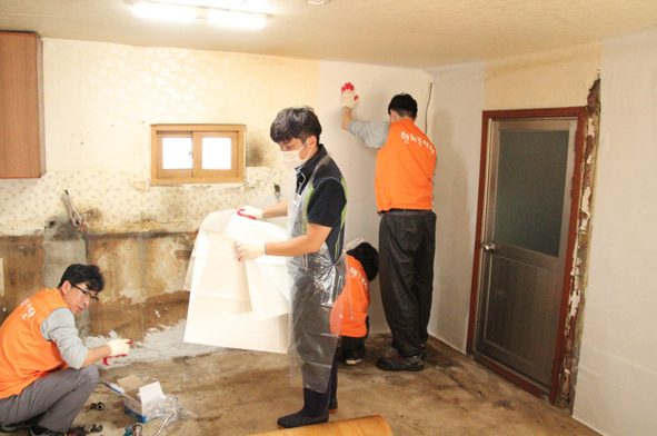 한화첨단소재 직원들이 생극면 재가노인 가정에서 벽지 도배작업을 진행하고 있다.