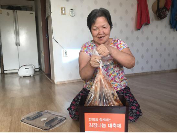 한화첨단소재 음성공장에서 전달한 김장김치를 전달받고 환하게 웃고 있는 장애인복지관 이용자 모습.
