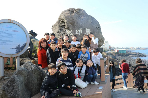 능산초 어린이들이 제주도 수학여행에서 용두암에 올라 기념촬영을 하고 있다.