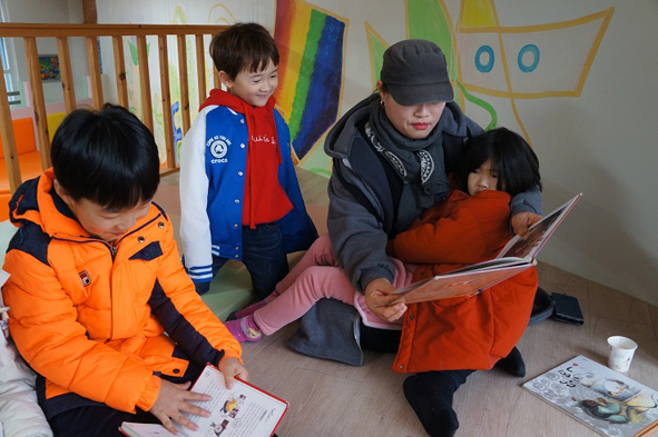 소이초 학부모가 어린이들에게 책을 읽어주고 있다.