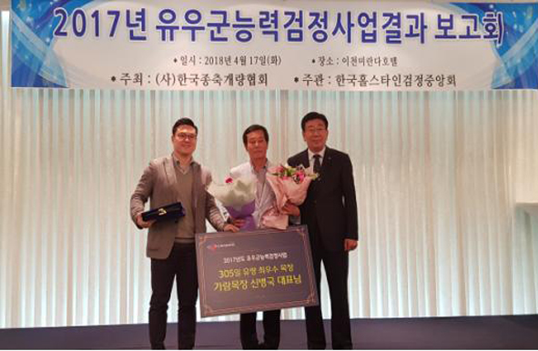 신병국 씨(사진 가운데)가 전국 젖소능력평가 대회에서 305일 유량 최우수 목장상을 수상하고 기념촬영을 하고 있다.