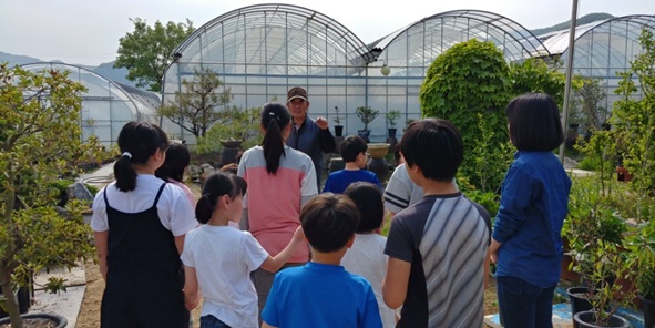 ▲청보리지역아동센터 아이들이 송석응 대표로부터 무궁화에 대해 설명을 듣고 있다.