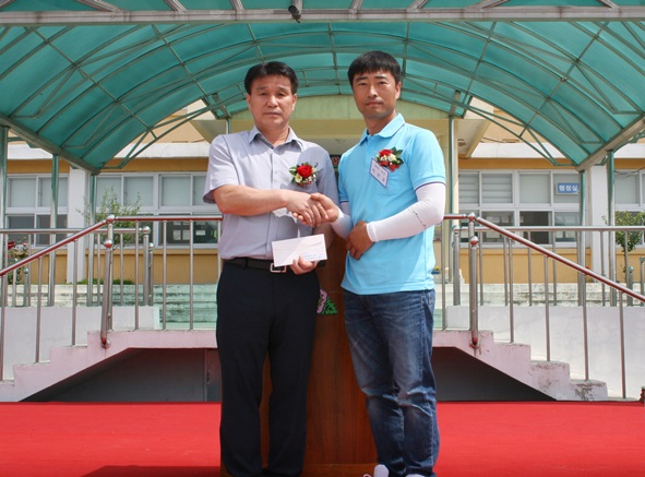 지선규 주관기 회장이 이상국 삼성초등학교 교장에게 학교발전기금을 전달했다.