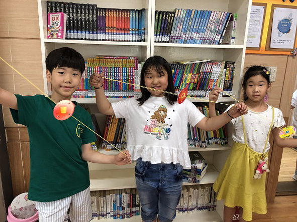 청룡초 어린이들이 도서실에서 실팽이를 만들며 즐거워하고 있다.