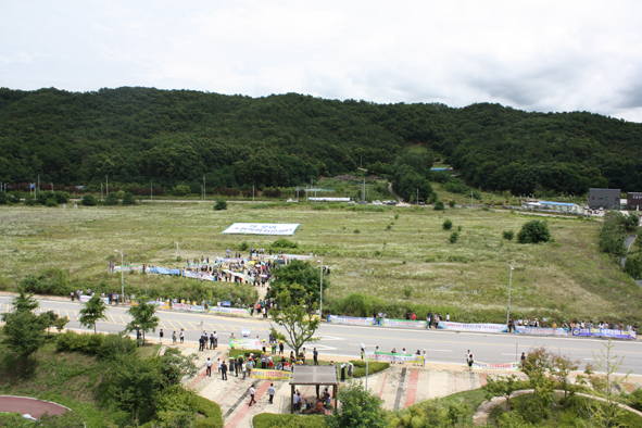 ▲소방복합치유센터 예정 부지와 실무조사단을 환영하기 위해 모인 군민들 모습.