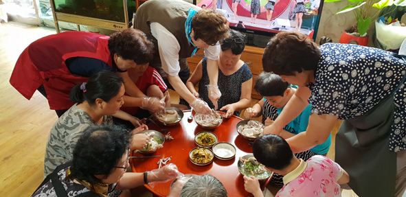 음성군바르게살기 여성회원들이 새생명장애인의집 이용자들에게 삼계탕을 대접하고 있다.