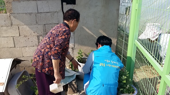 금왕읍지역사회보장협의체 회원이 Y할머니 집을 수리하고 있는 모습.