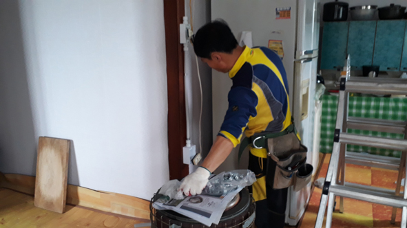 우진전업 직원이 독거노인 가정에 전기 시설을 점검하고 있다.