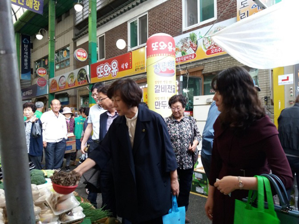 김덕순 음성교육장과 직원들이 무극시장 장보기 행사에 참여해 물건을 구매하고 있다.