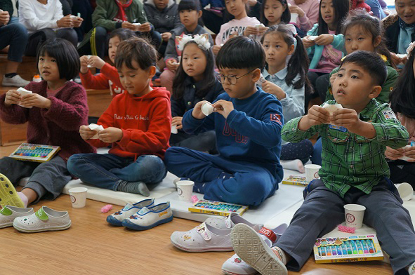 소이초 어린이들이 종이컵 인형극을 관람하고 있다.