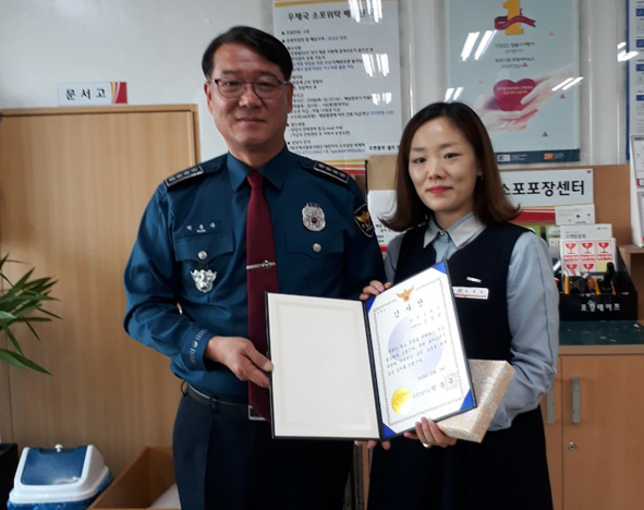 박봉규 경찰서장이 우체국 직원 K씨에게 감사장을 전달하고 기념촬영을 하고 있다.