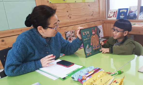 맹동초 상담교사 이순일 교사가 맹동초 어린이에게 책을 읽어주고 있다.