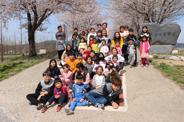 '어깨짝' 활동을 위해 응천벚꽃길에 나선 생극초 어린이들이 기념촬영을 하고 있다.