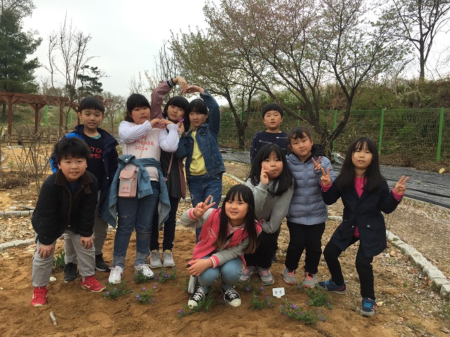부윤초 어린이들이 꽃을 심고 기념촬영을 하고 있다.