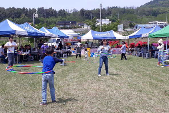 ▲관말의 날 잔치 훌라후프 경기에 참가한 주민들 모습.
