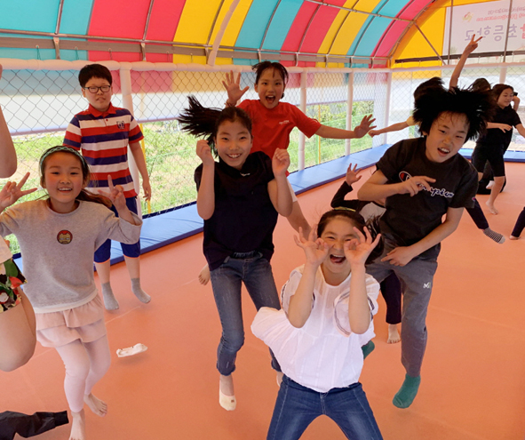 트렘폴린에서 뛰어놀며 오갑초 어린이들이 즐거워하는 모습.