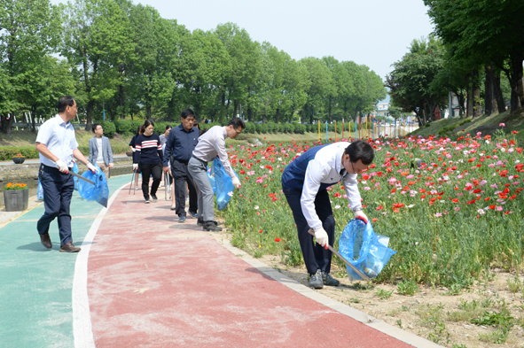 음성천 꽃밭 일원에서 환경정화활동에 참여하고 있는 조병옥 군수와 음성읍 공무원들 모습.
