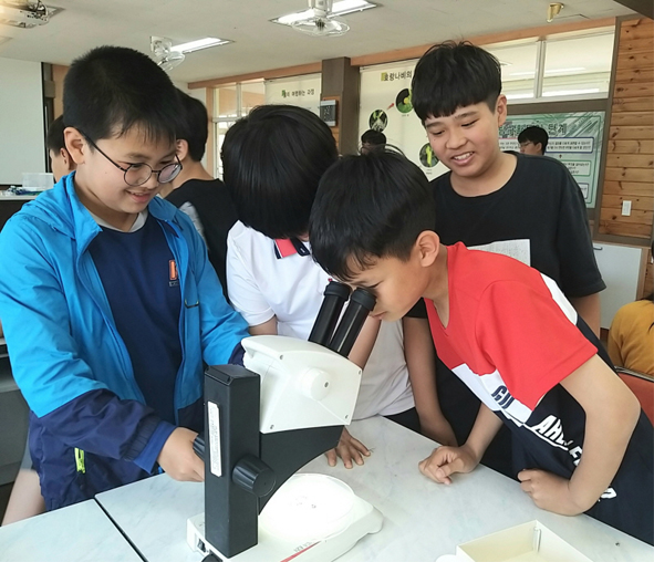 부윤초 어린이들이 생물학 박사와 함께하는 생물자연교실에 참여해 현미경으로 관찰하고 있다.