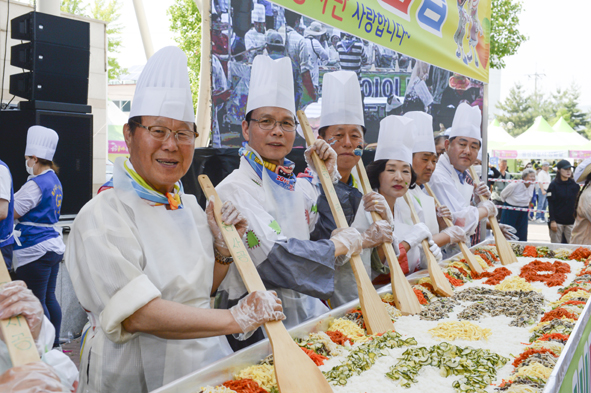 ▲음성품바축제 천인의 비빔밥 나누기 행사에서 비빔밥을 만들고 있는 내빈들 모습.