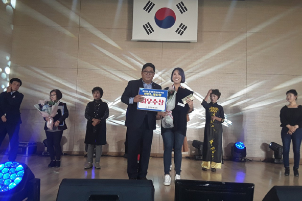 ▲감곡면민노래자랑 최우수상을 수상한 홍은영 씨가 김태호 체육회장과 기념촬영을 하고 있다.