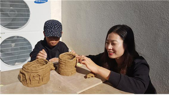 (주)한독봉사단원이 부윤지역아동센터 소속 어린이와 함께 도자기 만들기 체험을 하고 있다.
