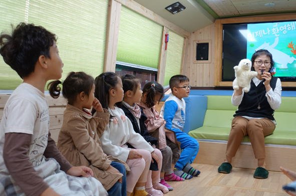 오갑초 어린이들이 꿈의 책버스에서 독서 프로그램에 참여하고 있다.
