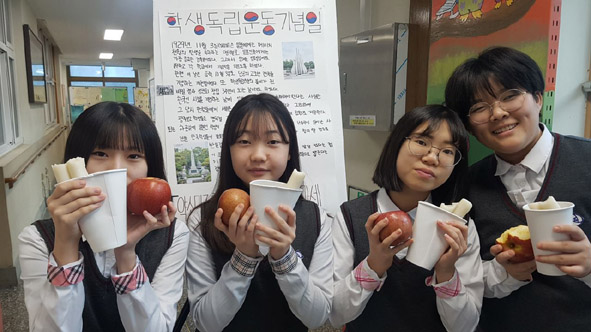 감곡 매괴여중 학생들이 학교에서 제공한 가래떡과 사과를 들고 기뻐하고 있다.
