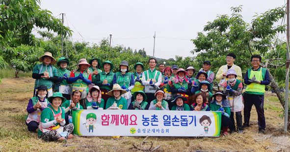 음성군 새마을회원들이 소이 김연홍 농가에서 농촌일손돕기 봉사활동을 전개하며 기념촬영을 하고 있다.