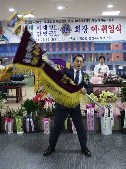 김영근 취임회장이 깃발을 인수해 흔들고 있다.