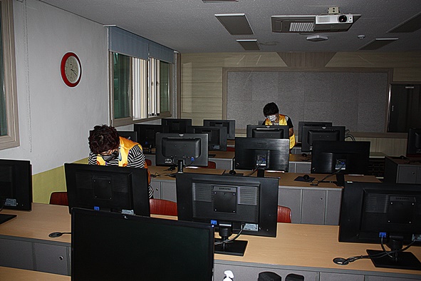 ▲다온라이온스 회원들이 맹동초 컴퓨터실에서 소독방역 활동을 전개하고 있다.
