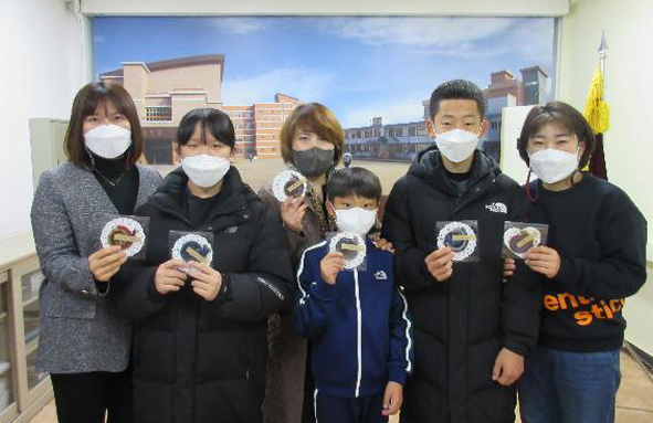 용천초학부모회가 학생들에게 마스크 목걸이를 전달하며 기념촬영을 하고 있다.