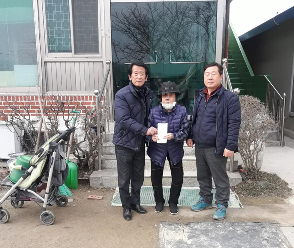 (주)영상코아에서 기탁한 성금을 저소득 독거노인에게 전달하고 기념촬영을 하고 있는 부윤1리 김훈열(사진 왼쪽)과 마을 임원이 기념촬영을 하고 있다.