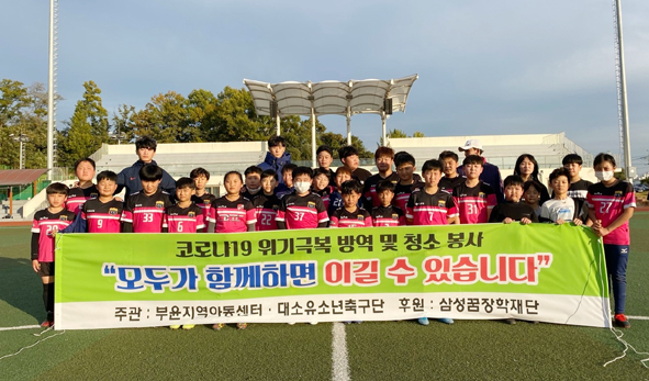 부윤지역아동센터가 운영하는 대소유소년축구단 관계자들이 코로나19 극복을 응원하며 기념촬영을 하고 있다.