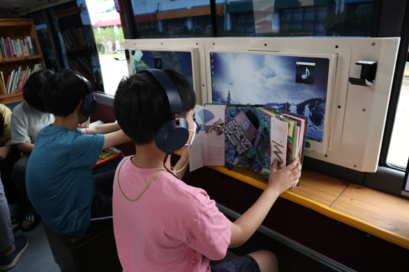책이음버스에서 독서하고 있는 청룡초 어린이들 모습.