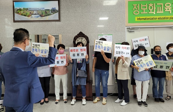 ▲피켓을 준비한 주민들이 김동연 전 부총리 이름을 부르며 환영하고 있다.