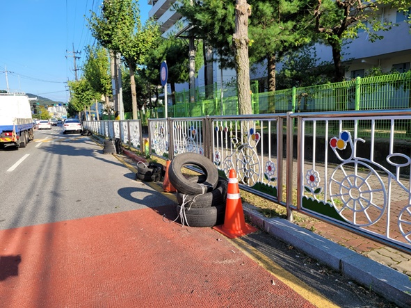 음성읍 한성APT 정문 앞 어린이보호구간 도로 위에 폐타이어들이 놓여 있다.