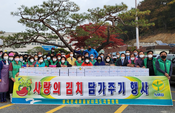 생극남여새마을회원들이 김장 담그기 행사를 하며 기념촬영을 하고 있다.