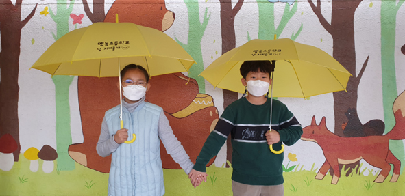 맹동초교에서 대여한 우산을 사용하고 있는 맹동초 어린이들 모습.