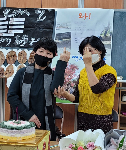 짓거리시문학회 회장 김순덕 시인(사진 오른쪽)이 이영옥 시인에게 축하 기념반지를 전달하고 둘이 기념반지를 보이며 기념촬영을 하고 있다.